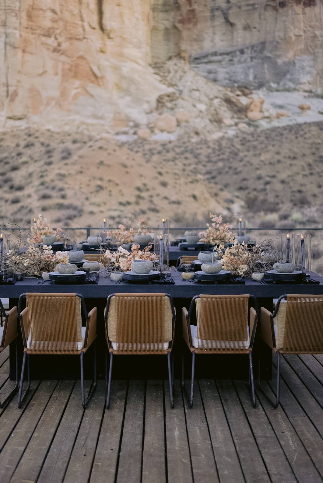 Chinle long-table dinner with woven Hive chairs against the Amangiri sandstone cliffs